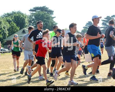 Kesgrave, Suffolk - 10. Juni 2023 : Parkrun an einem heißen, hellen Sommermorgen. Läufer Jung und Alt schnell und langsam, Erwachsene und Kinder. Stockfoto