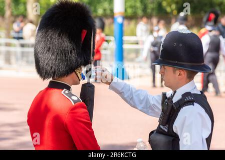 Westminster, London, Großbritannien. 10. Juni 2023. Trooping the Colour findet am 17. Juni statt und wird der erste unter König Karl III. Sein Die Überprüfung ist eine abschließende Bewertung der Militärparade vor der vollständigen Veranstaltung nächste Woche. Polizeibeamte helfen, die Streetliner-Soldaten während der Hitze des Tages mit Wasser zu versorgen. Bei heißem Wetter brachen einige der Truppen während der Parade zusammen Stockfoto