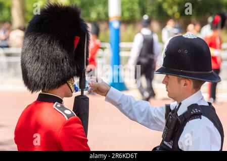 Westminster, London, Großbritannien. 10. Juni 2023. Trooping the Colour findet am 17. Juni statt und wird der erste unter König Karl III. Sein Die Überprüfung ist eine abschließende Bewertung der Militärparade vor der vollständigen Veranstaltung nächste Woche. Polizeibeamte helfen, die Streetliner-Soldaten während der Hitze des Tages mit Wasser zu versorgen. Bei heißem Wetter brachen einige der Truppen während der Parade zusammen Stockfoto