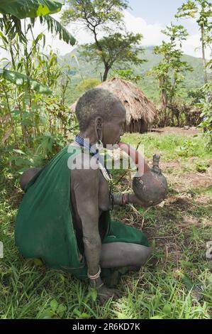 Alte Surma, die aus einer Riesenpfeife raucht, Kibisch, Omo Valley, Äthiopien, Afrika Stockfoto