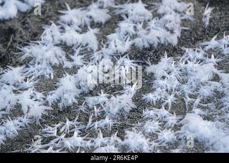 Eiskristalle, die auf gefrorenem Fluss und Sand Stacheln bilden, Makrodetails Stockfoto