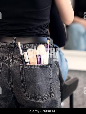 Make-up-Make-up-Künstler in einem Schönheitssalon vor einem Spiegel Stockfoto