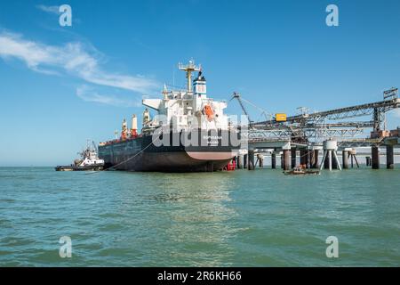 Wharf Operations: Schlepper, der dem Massengutfrachter Sophiana Majuro in Laayoune, Marokko, assistiert Stockfoto