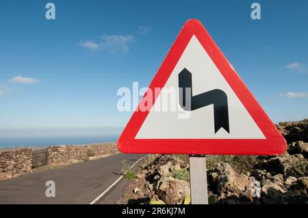 Kurven auf der Straße, dreieckiges Straßenschild. Stockfoto