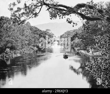 Ein Blick aus dem späten 19. Jahrhundert auf einen Bootsmann und Touristen beim Meeting of the Waters in Killarney, County Kerry, Irland. So benannt, weil es der Punkt ist, an dem die drei Seen von Killarney - der obere See, der Muckross See (der mittlere See) und Lough Leane (der untere See) - miteinander verschmelzen. Stockfoto