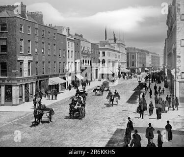 Ein Blick aus dem späten 19. Jahrhundert auf George's Street, die Hauptdurchgangsstraße der Stadt Limerick, die später nach Daniel O'Connell in O'Connell Street umbenannt wurde. Sie stammt aus dem späten 18. Bis zum frühen 19. Jahrhundert als Teil von Edmund Sexton Perys Plan für die Entwicklung einer neuen Stadt auf Landschaften, die ihm im Süden der bestehenden mittelalterlichen Stadt gehörten. 1765 beauftragte er den Ingenieur Davis Ducart, einen Stadtplan für die Länder zu entwerfen, die inzwischen als Newtown Pery bekannt sind. Das Herzstück dieser Entwicklung war die O'Connell Street, die heute zum Georgian Quarter von Limerick gehört. Stockfoto