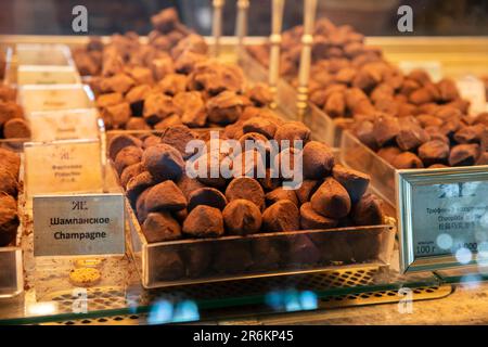 Schokoladen-Trüffel-Bisse mit Kakao am Schaufenster. Ein Haufen Schokoladentrüffel, verschiedene Schokoladen. Bonbonbälle verschiedener Art von Ch Stockfoto