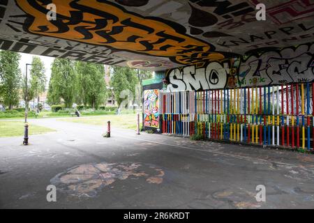 London, Großbritannien - Mai 17 2023: Blick unter einer Eisenbahnbrücke in Richtung Allen Gardens in Shoreditch. Die farbenfrohe Szene besteht aus Graffiti. Stockfoto