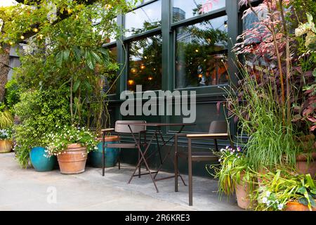 London, Großbritannien - Mai 17 2023: Ein einladender, leerer Tisch und Stühle an einem Café-Tisch im Freien im Restaurant Flat Iron in Spitalfields, East London. Stockfoto