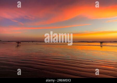 Surfer am Guiones Beach, wo viele kommen, um sich zu entspannen und bei Sonnenuntergang zu surfen, Playa Guiones, Nosara, Guanacaste, Costa Rica, Mittelamerika Stockfoto