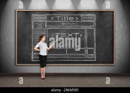 Eine Geschäftsfrau zeigt auf eine Kreidetafel mit einer Zeichenvorlagen-Website Stockfoto