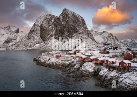 Rote norwegische Rorbuer Huts und Festhaeltinden Mountain im Winter, Hamnoy, Moskenes Municipality, Nordland County, Lofoten Islands Stockfoto