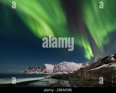 Die Aurora Borealis (Polarlichter) zeigen sich über den Devils Jaw (Devils Teeth) (Okshornan Mountains), Tungeneset, Senja, Troms Og Finnmark County Stockfoto