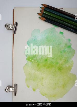 Farbige Bleistifte und Marker, Farben und Wasser lösen sich zu Aquarell auf Stockfoto
