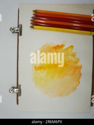 Farbige Bleistifte und Marker, Farben und Wasser lösen sich zu Aquarell auf Stockfoto