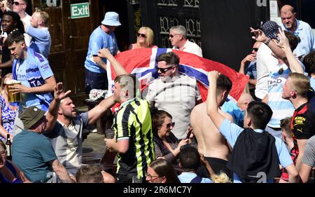 Manchester, Vereinigtes Königreich, 10. Juni 2023. Fans des Manchester City Football Clubs singen am Nachmittag vor dem Old Wellington Pub im Zentrum von Manchester, Großbritannien, vor dem Finale der UEFA Champions League 2022-23 zwischen man City und Inter Mailand im Atatürk Olympiastadion in Istanbul, Türkei. Kredit: Terry Waller/Alamy Live News Stockfoto