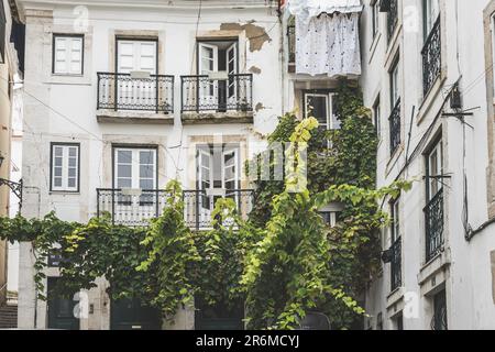 Klassisches altes Apartmentgebäude mit Balkonen und trocknender Kleidung in Lissabon, Portugal Stockfoto