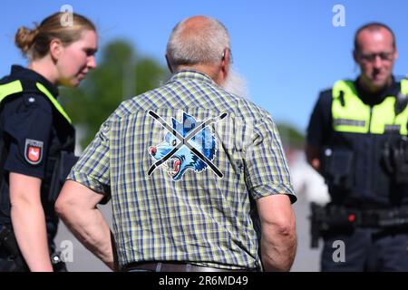 Aurich, Deutschland. 10. Juni 2023. Hans-Jürgen Bruns (M), Organisator der Demonstration, spricht vor der Veranstaltung mit Polizeibeamten. Die Vereinigungen Land schafft Verbindung (LSV) Ostfriesien und der friesische Naturschutzverband (FVN) haben eine Demonstration gegen die aktuelle Wolfspolitik gefordert. Kredit: Lars Penning/dpa/Alamy Live News Stockfoto