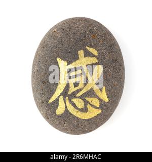 Chinesischer Schriftzug gan oder japanisches Kan, was Gefühl bedeutet, geschrieben auf einem vulkanischen Felsstein Stockfoto