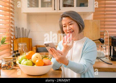 Seniorporträt. Fröhliches lächelndes Seniorporträt. Reife Frau, die telefoniert. Stockfoto