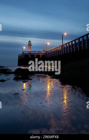 Ein Leuchtturm, der bei Sonnenuntergang am Pier in Nieuwpoort, Belgien, hoch am Dock steht Stockfoto