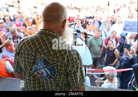 Aurich, Deutschland. 10. Juni 2023. Hans-Jürgen Bruns, Organisator der Demonstration, spricht auf einer Bühne zu den Teilnehmern der Veranstaltung. Die Vereinigungen Land schafft Verbindung (LSV) Ostfriesien und der friesische Naturschutzverband (FVN) haben eine Demonstration gegen die aktuelle Wolfspolitik gefordert. Kredit: Lars Penning/dpa/Alamy Live News Stockfoto