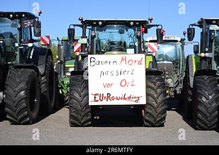 Aurich, Deutschland. 10. Juni 2023. Am Rande der Veranstaltung ist ein Schild mit der Aufschrift „Bauernmord geschieht lokal“ an einem Traktor angebracht. Die Vereinigungen Land schafft Verbindung (LSV) Ostfriesien und der friesische Naturschutzverband (FVN) haben eine Demonstration gegen die aktuelle Wolfspolitik gefordert. Kredit: Lars Penning/dpa/Alamy Live News Stockfoto