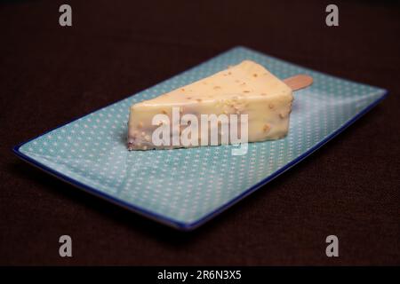 Köstliches dreieckiges Dessert mit zarter Füllung auf einem blauen Teller. Stockfoto