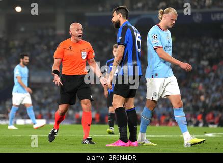 Schiedsrichter Szymon Marciniak (links) reagiert auf Francesco Acerbi von Inter Mailand, während Erling Haaland (rechts) von Manchester City beim Finalspiel der UEFA Champions League im Atatürk-Olympiastadion in Istanbul vorbeiläuft. Foto: Samstag, 10. Juni 2023. Stockfoto