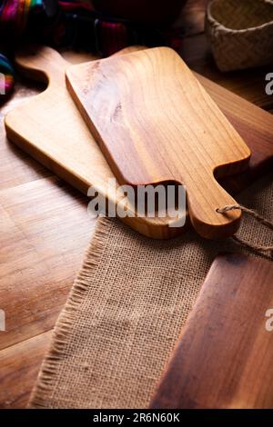 Leeres rustikales Holzschneidebrett für die Küche auf altem Holztisch. Stockfoto