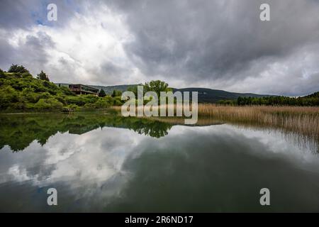 Laguna de Una an einem wolkigen und grauen Tag mit Wolken, die sich im Wasser spiegeln Stockfoto