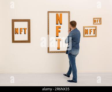 Mann auf der Ausstellung in der Galerie, Rückansicht. Bilder mit Abkürzungen NFT Stockfoto