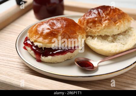 Frisch gebackene Soda-Wasser-Scones mit Preiselbeermarmelade auf Holztisch, Nahaufnahme Stockfoto