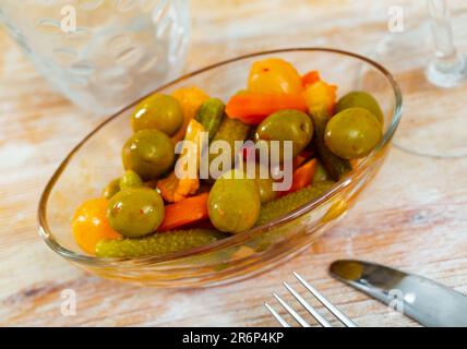 Grüne Oliven serviert mit Gurke, Karotte, Knoblauch und Zwiebeln Stockfoto
