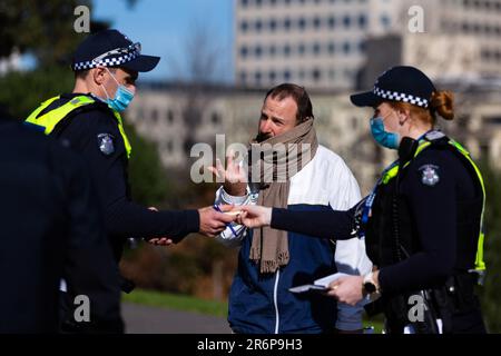 MELBOURNE, AUSTRALIEN - JULI 31: Ein Mann wird von der Polizei befragt und wurde später mit einem Befehl versehen, den er während der COVID-19-Pandemie am 31. Juli 2020 in Melbourne, Australien, befolgte. Anti-Gesichtsmaske-Demonstranten treffen sich am Schrein der Erinnerung einen Tag nachdem Victoria einen neuen Rekord in Coronavirus-Fällen sieht. Stockfoto