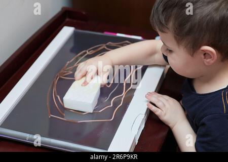 Zeichnung für Kleinkinder mit Markern auf einer Kunststoff-Lichttafel Stockfoto