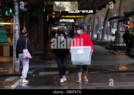 MELBOURNE, VIC - 12. SEPTEMBER: Ein Paar geht während der Stage 4 Restrictions am 12. September 2020 in Melbourne, Australien, über eine Kreuzung im Regen. Für die Metropolregion Melbourne gelten ab Sonntag, den 2. August, 6pm Uhr, Einschränkungen der Stufe 4. Dies beinhaltet eine Ausgangssperre jeden Abend von 8pm bis 5am Uhr. Während dieser Zeit dürfen Menschen ihr Haus nur zur Arbeit und aus wesentlichen Gesundheits-, Fürsorge- oder Sicherheitsgründen verlassen. Trotzdem werden mehrere Proteste organisiert, um gegen die drakonischen Beschränkungen im städtischen Melbourne vorzugehen. Ein Freedom Walk wurde für mich arrangiert Stockfoto