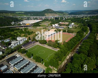 Bad Neuenahr, Deutschland. 09. Juni 2023. Eines der Trainingsfelder (M) des Stadions Apollinaris wurde nach der Flutkatastrophe restauriert (Luftaufnahme mit Drohne). Wegen der Flutkatastrophe gab es in Bad Neuenahr-Ahrweiler zwei Jahre lang nur einen Sportplatz. Auf einem anderen Trainingsgelände (vorne) gibt es immer noch Tiny-Houses, in denen von Überschwemmungen betroffene Menschen leben. (Zu dpa 'erster Sportplatz, der seit der Flut in Bad Neuenahr-Ahrweiler gebaut wurde') Kredit: Thomas Frey/dpa/Alamy Live News Stockfoto