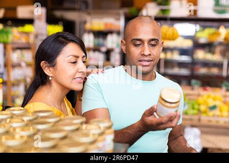 Ehepaar, das sich für Konserven im Supermarkt entschieden hat Stockfoto