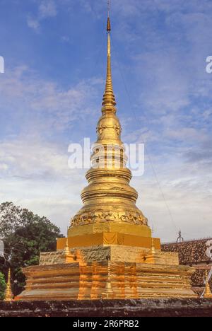 Der herrliche vergoldete Lanna-Cheedi von Wat Phra aus dem 14. Jahrhundert, Chae Haeng, liegt auf einem Hügel mit Blick auf Nan, eine Stadt im Norden Thailands. Stockfoto