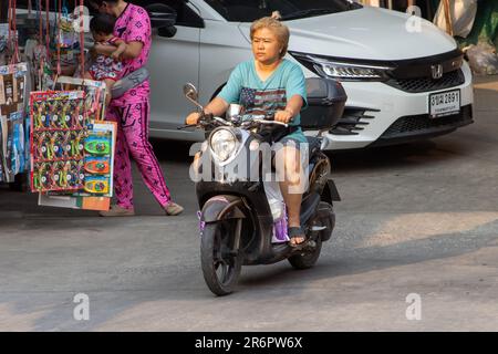 SAMUT PRAKAN, THAILAND, MÄRZ 03 2023, Eine Frau mit Gesichtsmaske fährt ein Motorrad Stockfoto