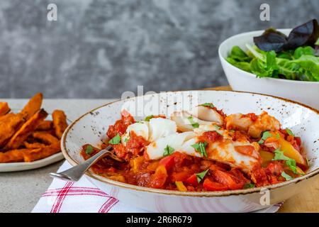 Sizilianischer Fisch mit Pfeffersoße und Süßkartoffelchips Stockfoto