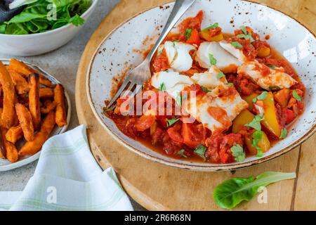 Sizilianischer Fisch mit Pfeffersoße und Süßkartoffelchips Stockfoto