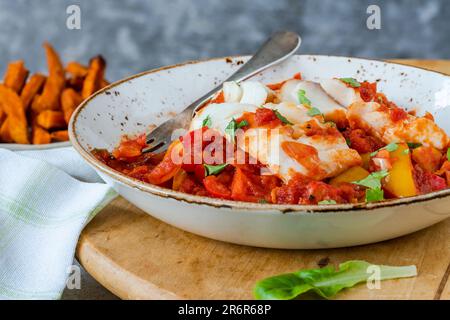 Sizilianischer Fisch mit Pfeffersoße und Süßkartoffelchips Stockfoto