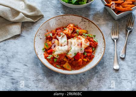 Sizilianischer Fisch mit Pfeffersoße und Süßkartoffelchips Stockfoto