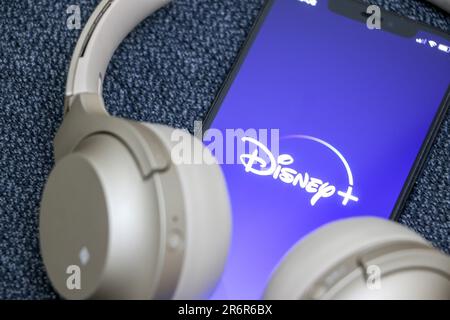 Disney Plus auf dem Smartphone, Disney + Logo auf dem Bildschirm, goldene Kopfhörer, rundes Gerät, Online-Streaming-Konzept, Disney Plus ist Disney's eigene Massi Stockfoto