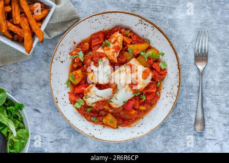 Sizilianischer Fisch mit Pfeffersoße und Süßkartoffelchips Stockfoto