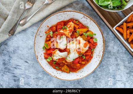 Sizilianischer Fisch mit Pfeffersoße und Süßkartoffelchips Stockfoto