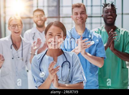Professionelle multinationale Ärzte applaudieren vor der Kamera. Diagnosediskussion Stockfoto