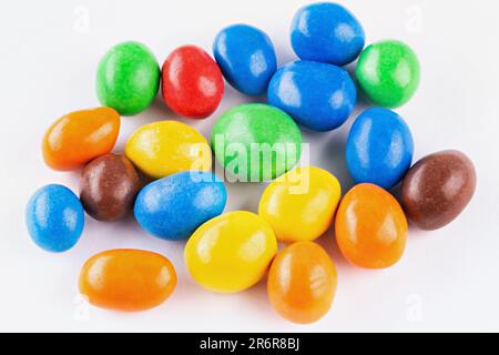 Bunte Schokoladen-Knöpfe, auf weißem Hintergrund. Schokoladenbeschichtete Erdnüsse. Stockfoto